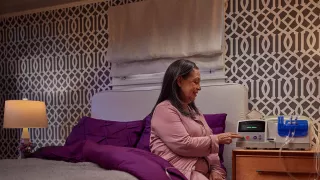 Woman sitting on the side of the bed and tabs button on monitor